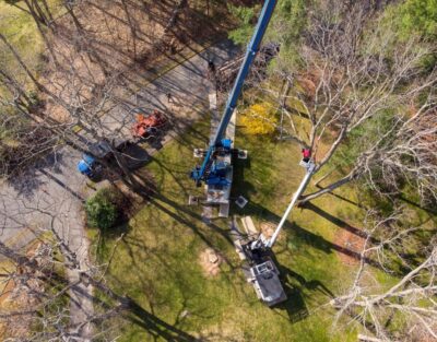 The American Climbers team using a bucket truck and crane to trim a tree in Sudbury, MA
