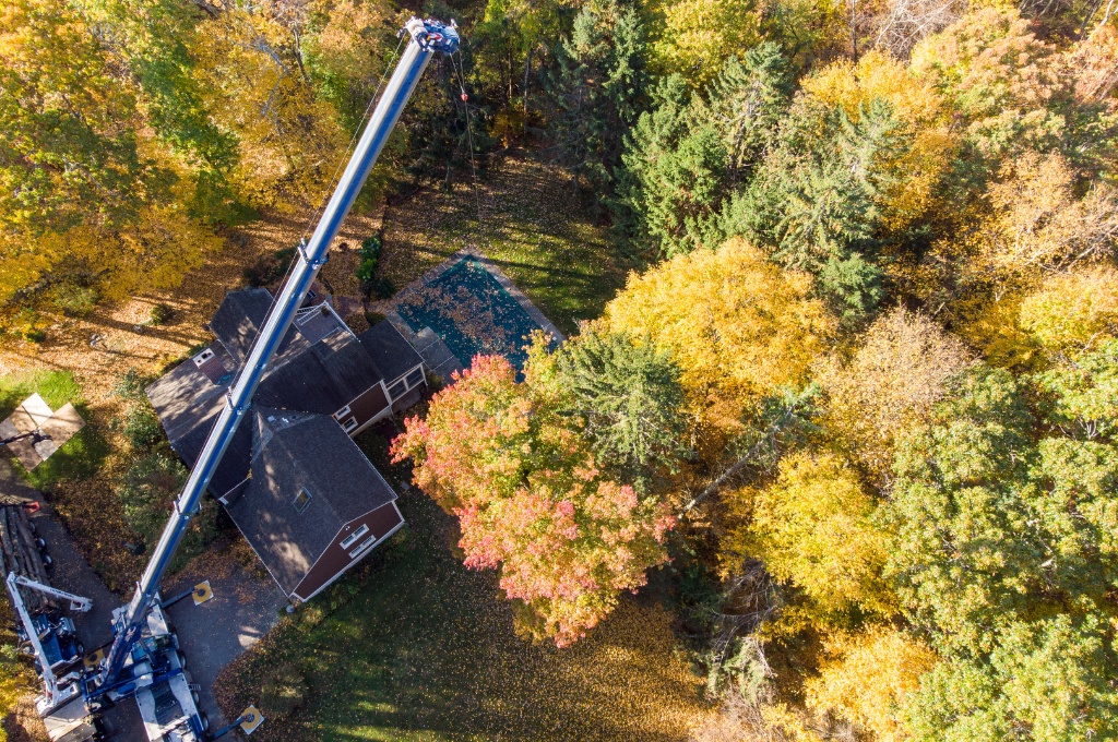 An aerial shot of the american climbers tree removal crane removing a hazardous tree in the fall.
