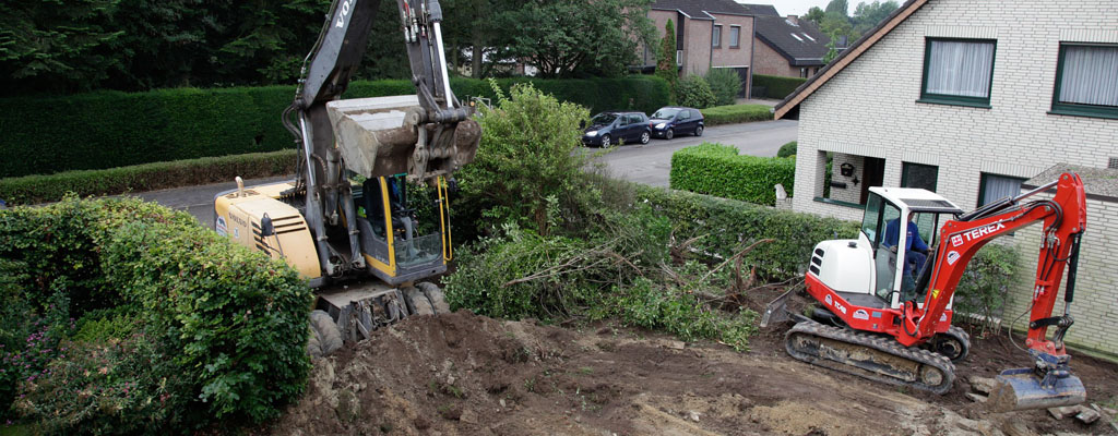 Construction equipment on the lawn of a homeowner with torn up dirt, grass, and bushes