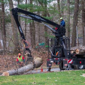 The American Climbers removal crew uses a grapple arm on a knuckle boom to lift a large section of tree. Massachusetts law has determined that the property owner is probably responsible for a fallen tree in this case.
